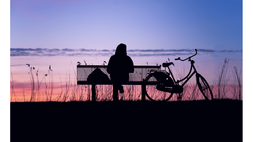 person sitting quietly on bench outdoors