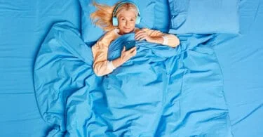 Woman in bed with headphones