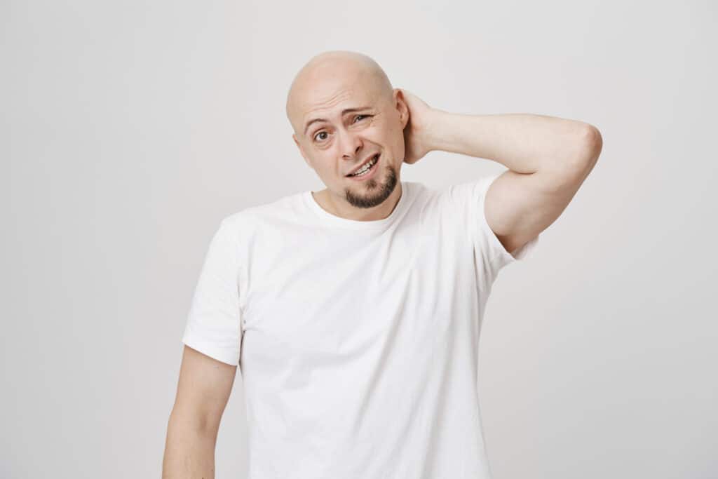 Man scratching his head with puzzled look