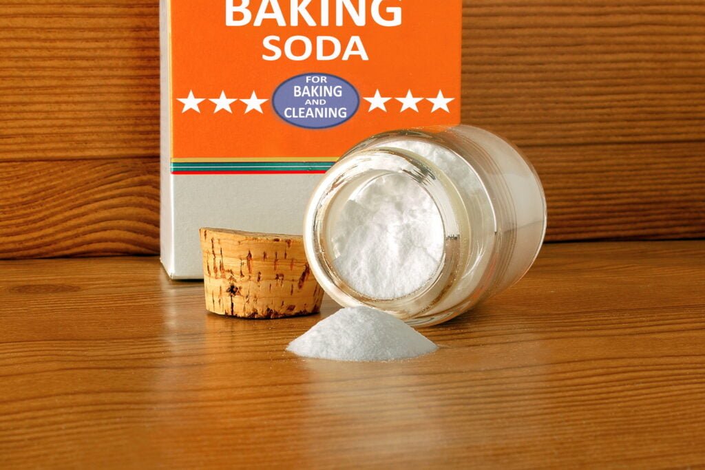 baking soda or baking powder in bottle isolated in wooden backgr Box and storage jar of containing baking soda