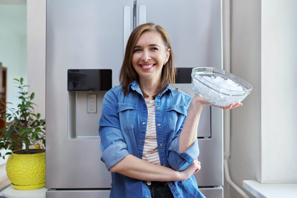 Woman with bowl with ice cubes for cooling food Woman happily holding bowl of fresh ice