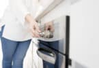 woman using control panel on dishwasher